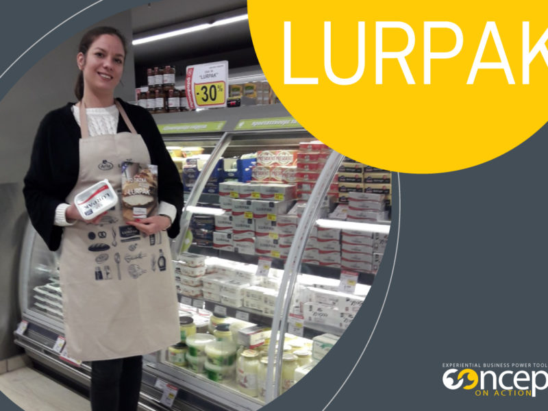 promoter της Concept on Action προωθεί προϊόντα Lurpak μπροστά από ψυγείο Super market